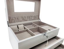 Closeup of open jewelry box with compartments on a white background