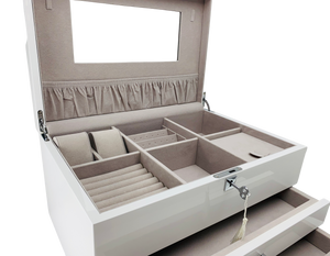 Closeup of open jewelry box with compartments on a white background
